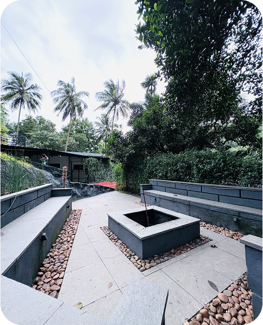 Cozy campfire evening at JKR Gardens Resort: Guests gathered around a glowing campfire, enjoying music, storytelling, and the warmth of the fire under the starlit sky in Kerala and Tamil Nadu.