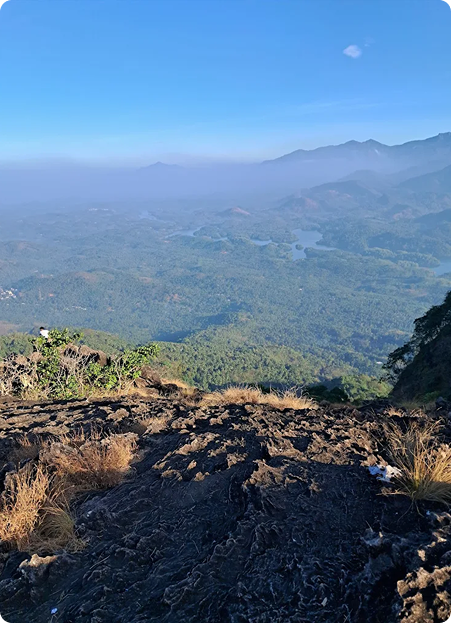 Modern lounge area with curved blue and orange seating, bean bags, and a large projection screen displaying a video game menu. Pink accent lighting streams from tall windows, creating a vibrant, playful environment ideal for socializing or gaming. No visible text. The mood is energetic and inviting.