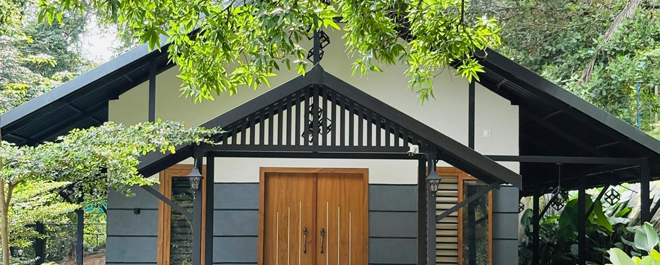 Resort facilities at JKR Gardens: Outdoor swimming pool surrounded by palm trees and sun loungers, guests relaxing by the water, modern resort buildings in the background, and lush greenery creating a serene, welcoming atmosphere. No visible text in the image.