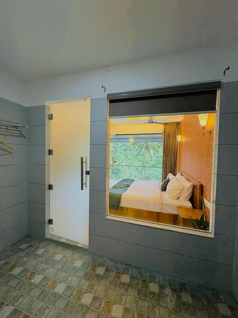 Glass cottage in Kerala with sliding glass doors at Vayalada