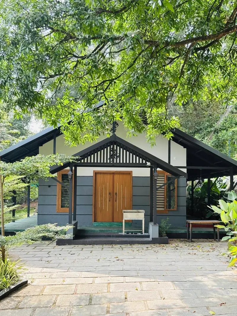 Vayalada Gardens Resort entrance cottage with forest backdrop