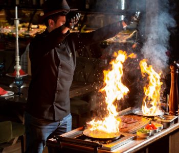 chef-putting-salt-into-two-burning-pans-with-oil